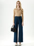 Model standing in beige ribbed sweater and dark blue wide leg cropped jeans.