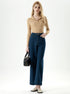 Woman posing in blue cropped jeans with high waist and button detail.
