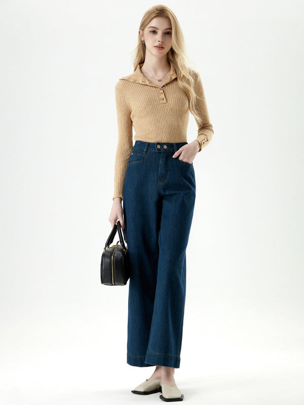 Woman posing in blue cropped jeans with high waist and button detail.
