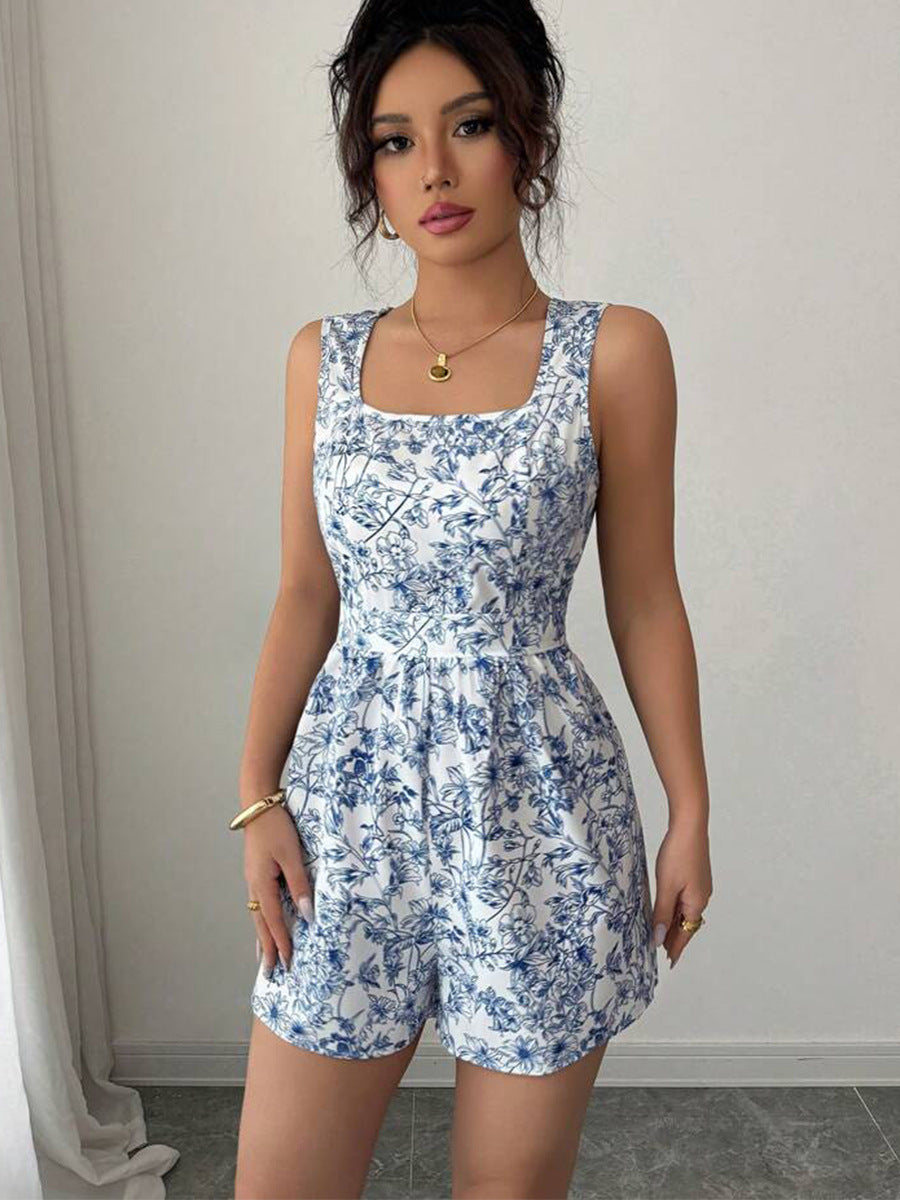 Woman wearing a blue floral romper against a plain background