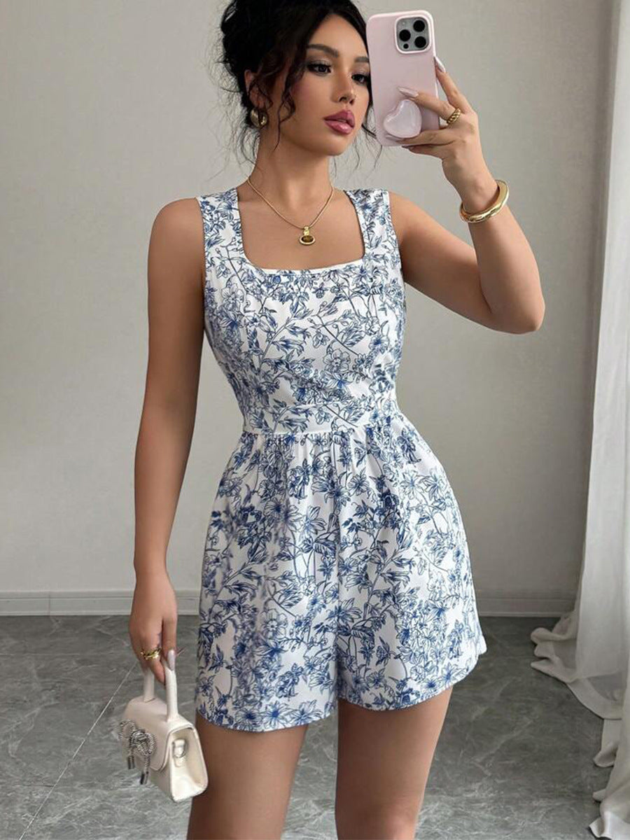 Woman taking a mirror selfie wearing a blue floral romper.
