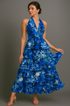 Woman wearing a blue halter floral dress against a gray background
