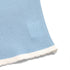 Hem detail of blue knit cami with white scalloped trim and textured fabric.