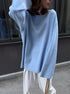 Side view of woman in light blue knit sweater outdoors