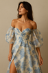 Woman wearing a floral off-shoulder dress with puffed sleeves against a beige background