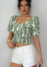 Front angle of leafy smocked crop top with ruffled hem