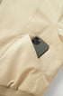 Beige bomber pocket with phone, hidden snap pocket detail