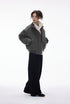 Model in gray bomber jacket, zip open over hoodie, side step