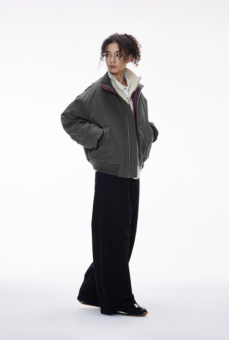 Model in gray bomber jacket, zip open over hoodie, side step