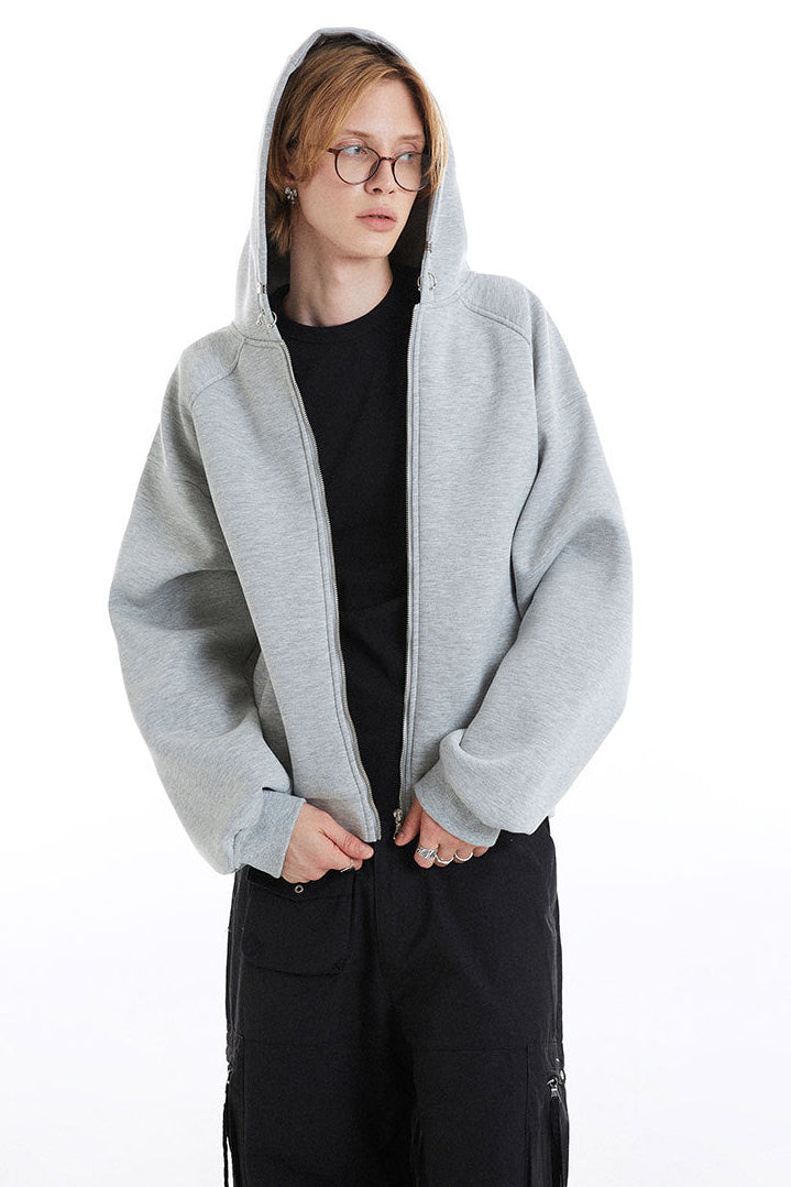 Light gray cropped hoodie worn with the hood up, showing the full front zipper
