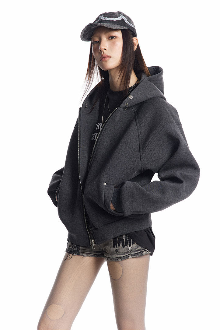 Three-quarter view of the charcoal zip-up hoodie with rivet-trimmed welt pocket