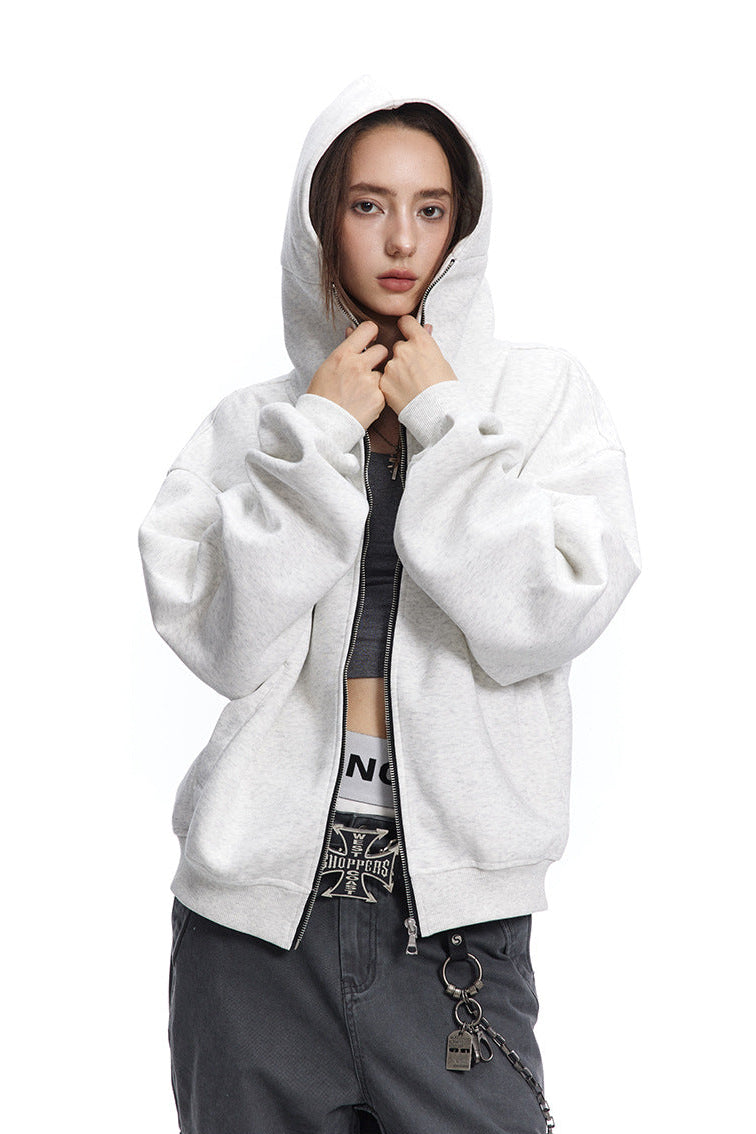 Medium shot of a model wearing the hood up on a heather light grey full zip hoodie sweatshirt.