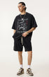 Model wears vintage black "Breakthrough" tee with matching shorts and sneakers.