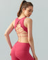  Back view of brick red strappy open-back sports bra and matching leggings.