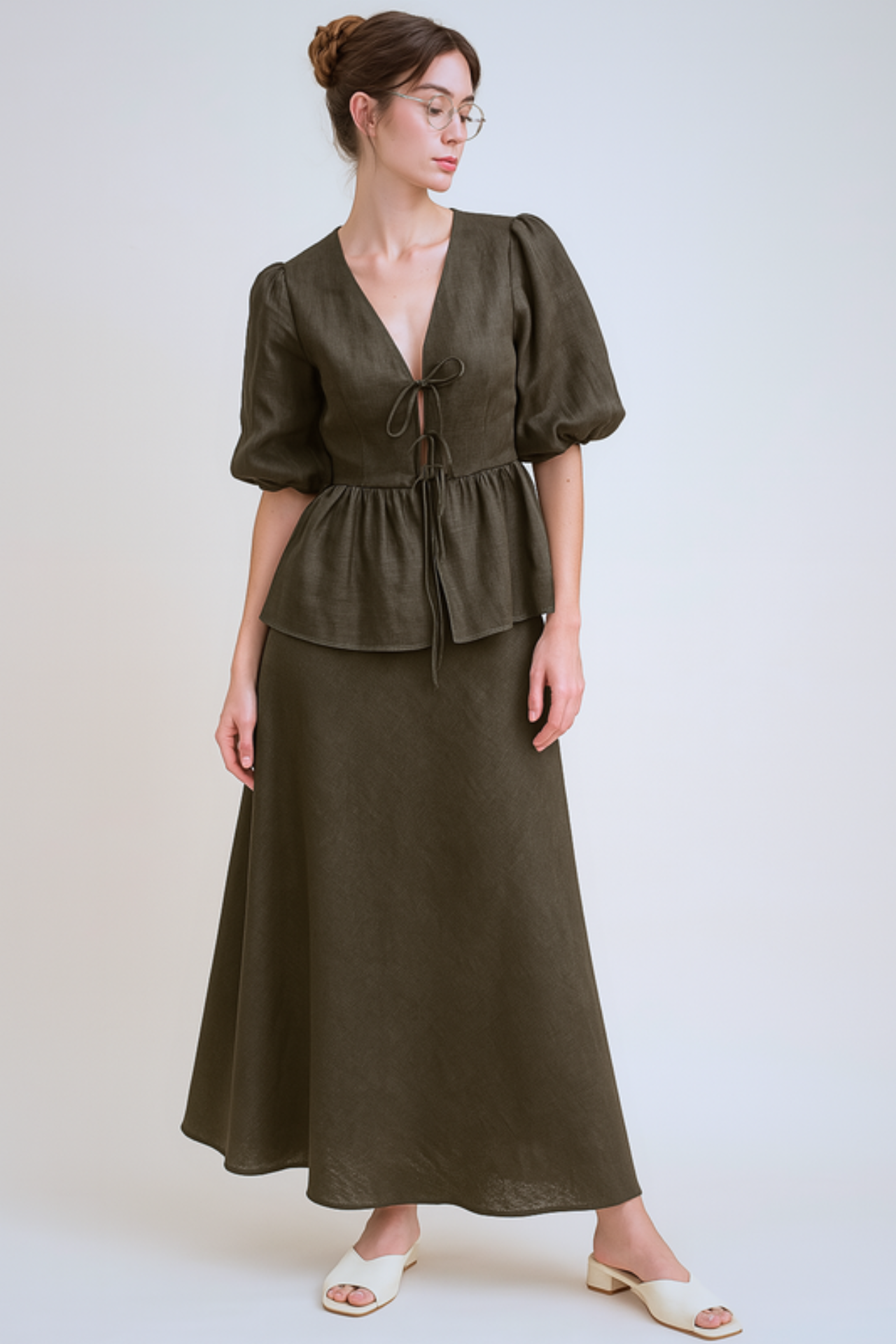 Woman wearing a brown skirt set with puff sleeves against a beige background