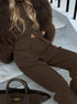 brown ribbed co ord set worn by model sitting close-up pants detail