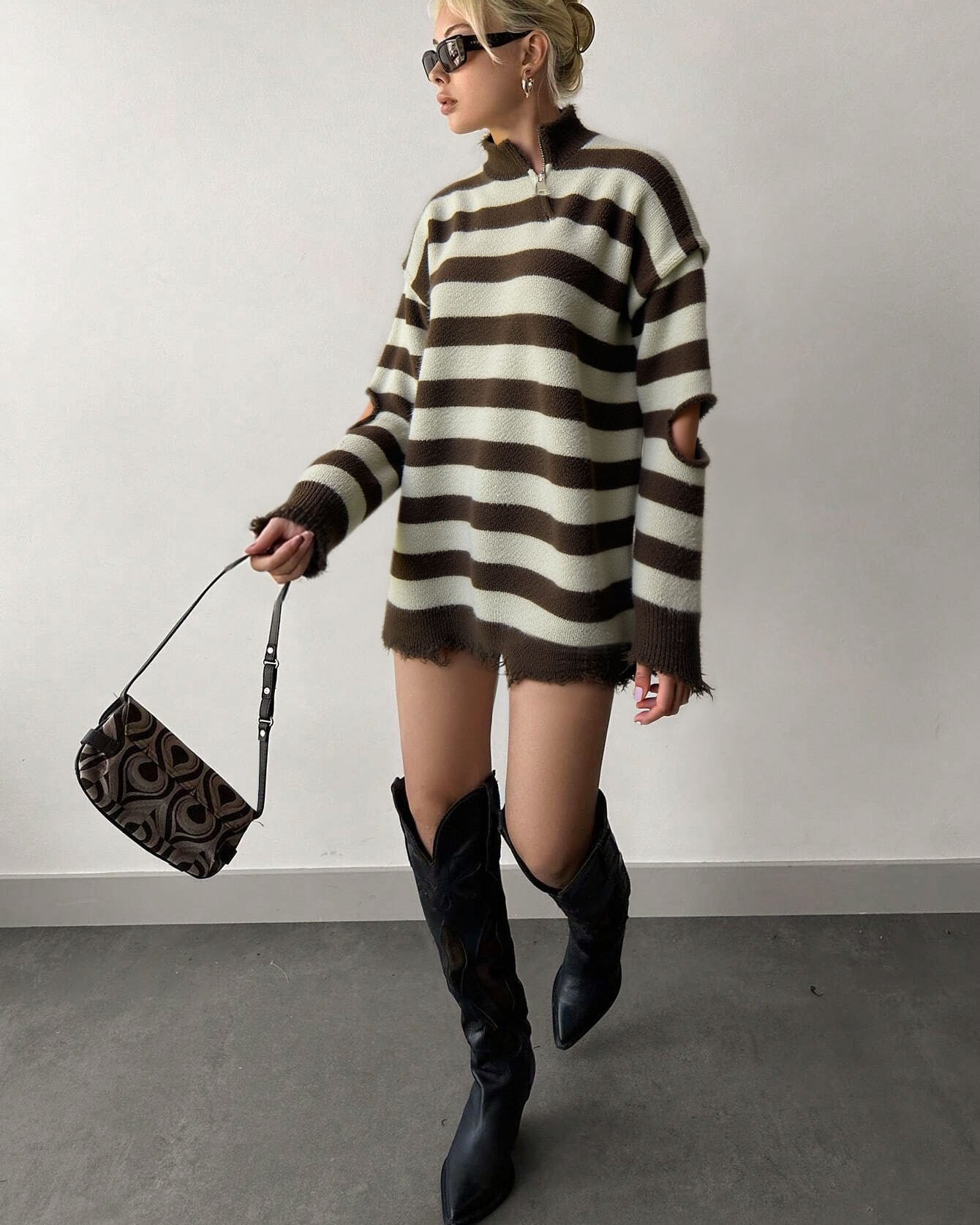 model wearing brown striped quarter zip sweater with knee boots in streetwear look