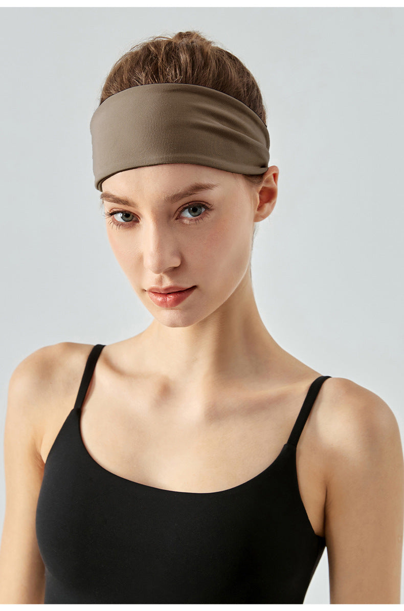 Front view of woman wearing brown workout headband.