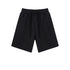 Black cotton shorts with elastic waistband and twin drawstring ties, featuring a relaxed fit and clean minimal design against white background