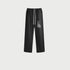 Black sweatpants displayed flat showing elastic waistband, white drawstring, side pockets and streetwear graphic detail