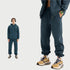 Navy blue sweatsuit showcased in split-view format with full outfit on left and close-up detail of jogger leg and beige/navy sneakers on right against white background