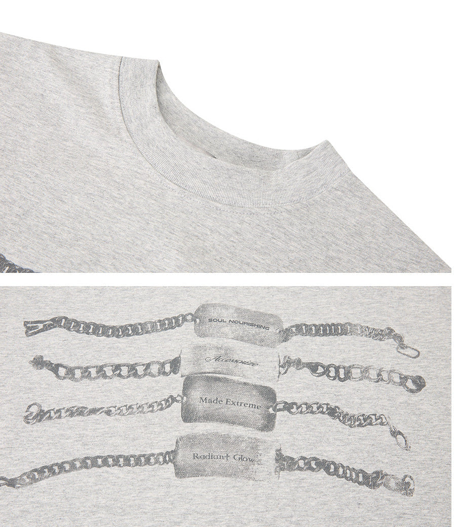 Close-up of heather gray chain graphic T-shirt showing the ribbed crew neck and monochrome metal-tag print