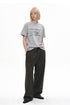 Three-quarter view of heather gray chain graphic T-shirt styled with pleated trousers