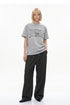 Front full-length view of relaxed heather gray chain graphic T-shirt with tailored pants