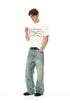 Model wearing a white chain graphic T-shirt with light-wash wide-leg jeans