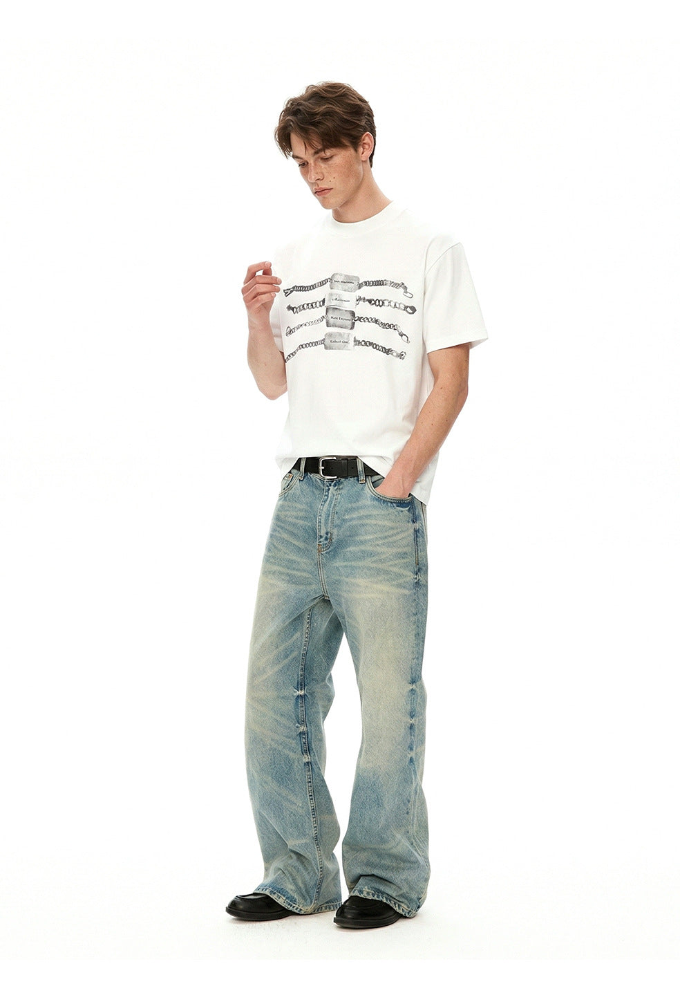 Model wearing a white chain graphic T-shirt with light-wash wide-leg jeans