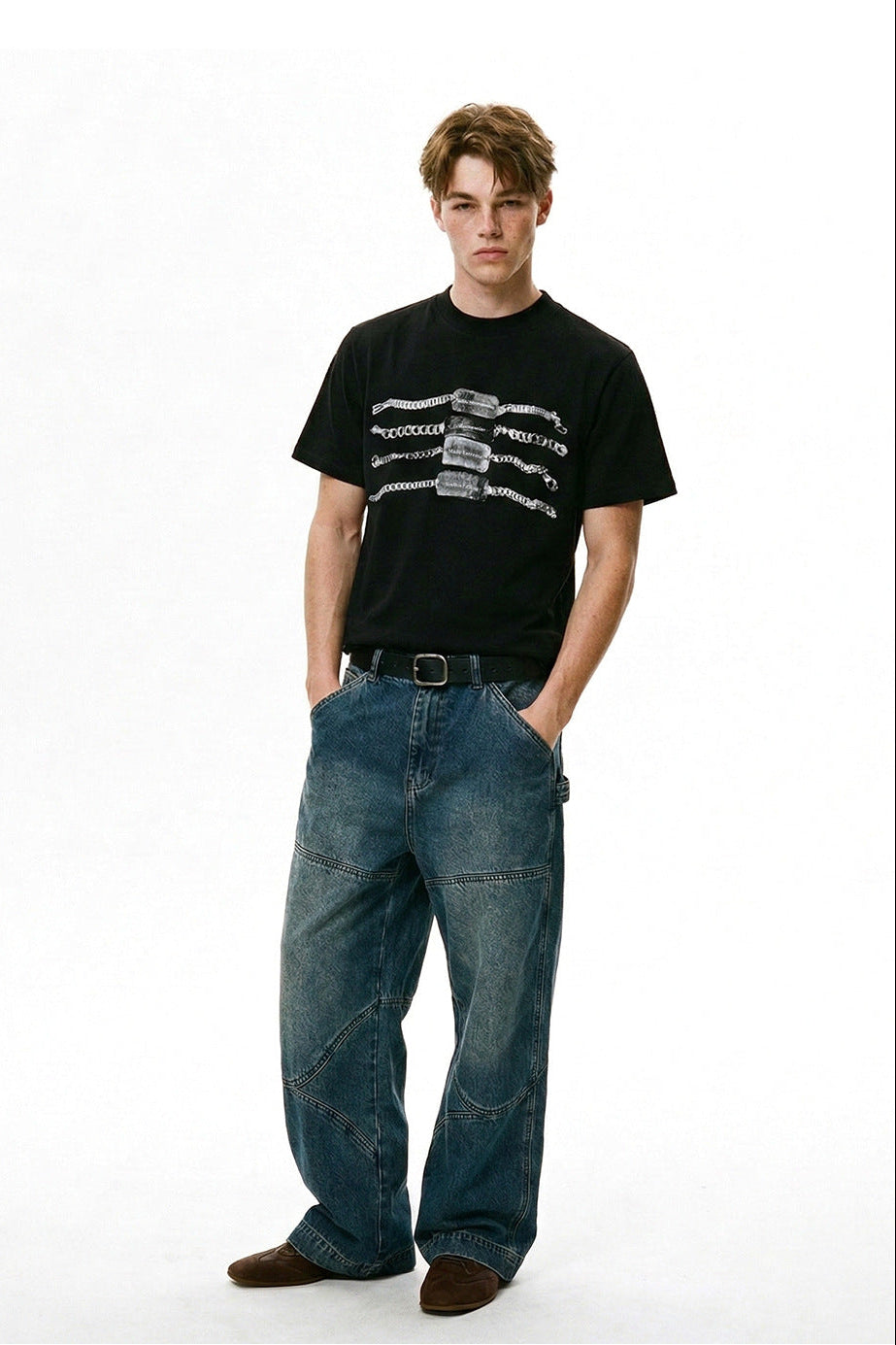 Model wearing a black chain graphic T-shirt with wide-leg blue jeans