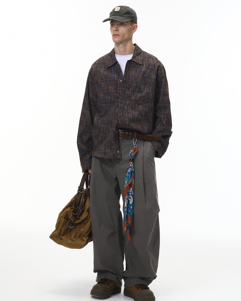 Model in charcoal corduroy pants with plaid shirt, relaxed street fit