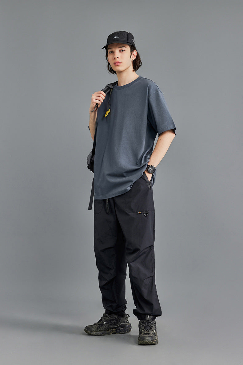 Unisex charcoal oversized tee, black shorts, studio shot
