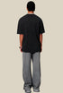 Back view of man wearing black pixel tee with washed texture and relaxed fit