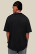 Model showing back of black oversized tee with raw hem and relaxed shoulders