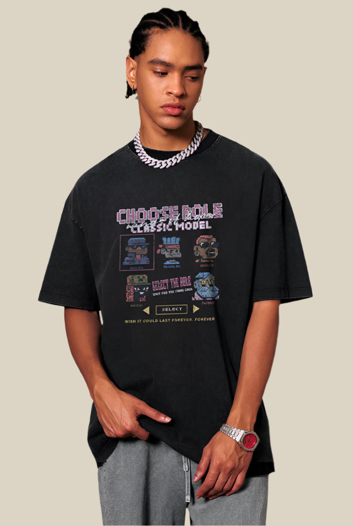 Model pointing to hem of pixel tee, styled with grey washed pants
