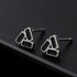 Close-up of geometric stud earrings on matte black edge.