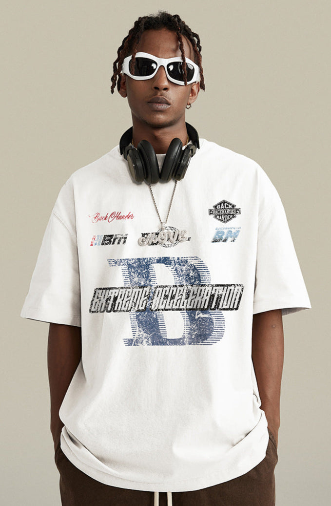 Close-up of white tee with racing graphics and silver chain.