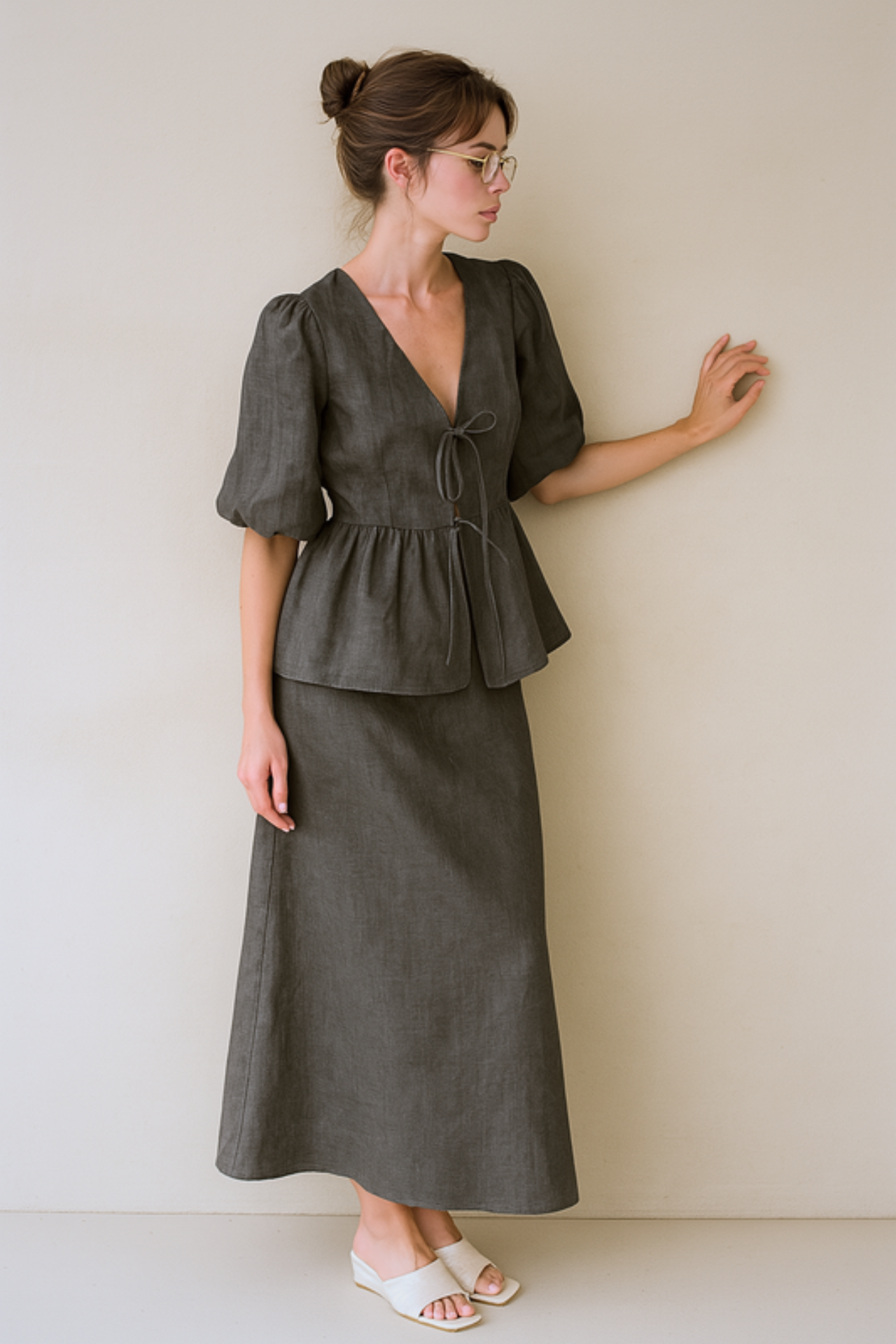 Woman wearing a brown skirt set against a beige wall