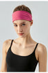 Woman wearing a wide cranberry headband and black sports top, front view.