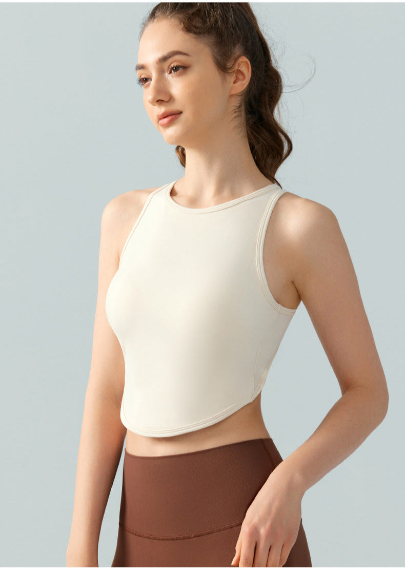 Woman in cream high-neck crop top and brown leggings, facing slightly to the side.