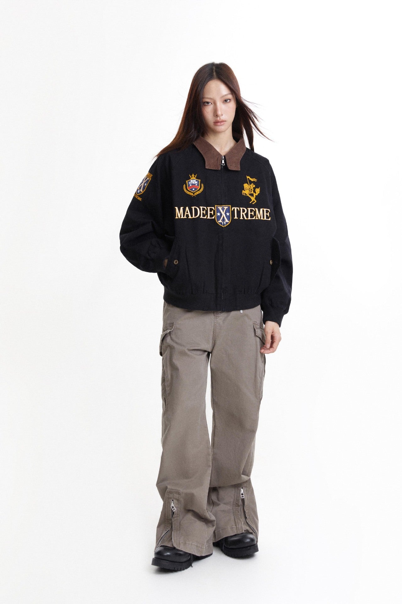 Model wearing black embroidered Detroit jacket with wide gray cargo pants