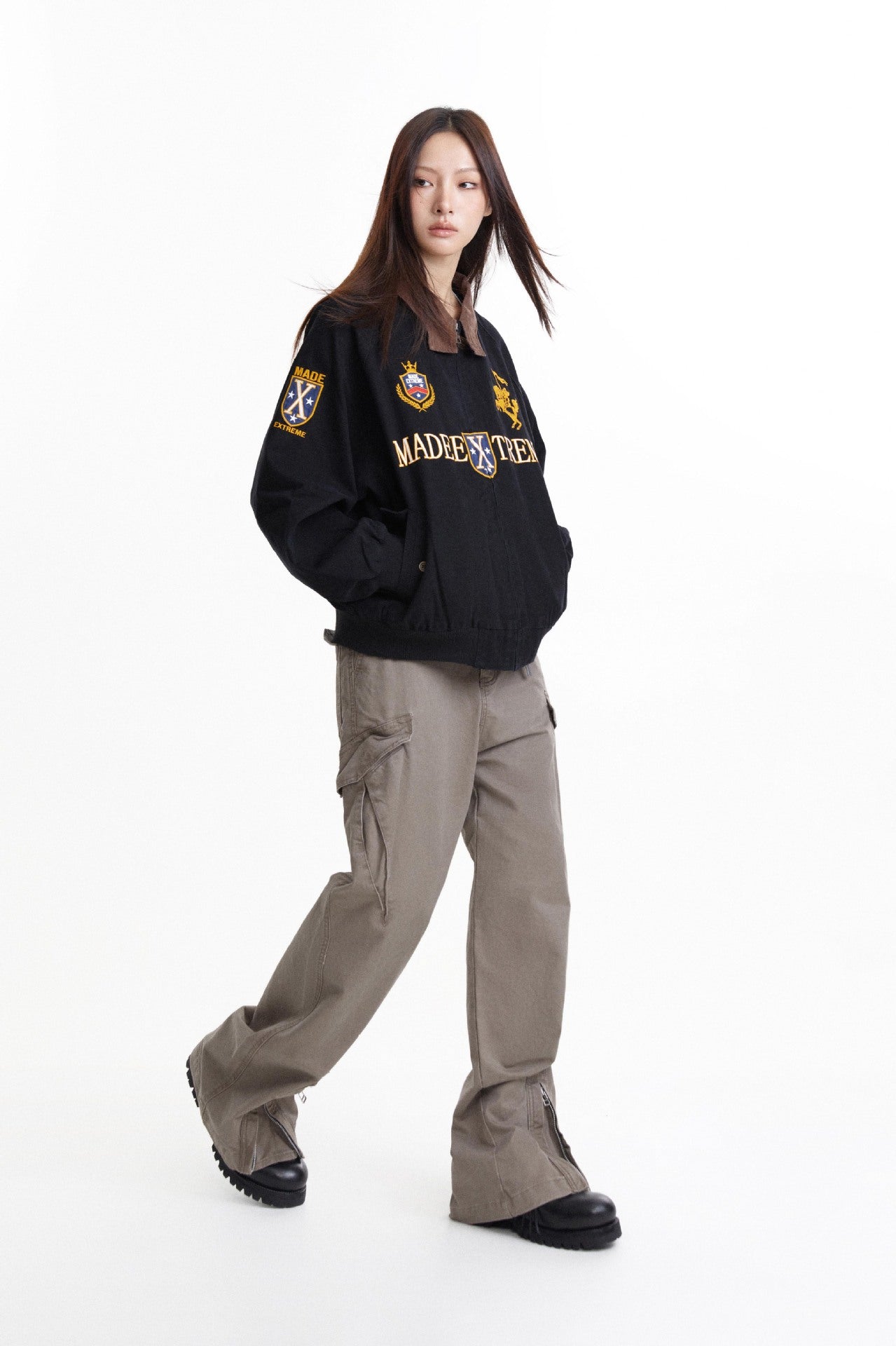 Three-quarter view of black work jacket showing contrast collar and sleeve crest