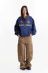 Model wearing blue embroidered Detroit jacket with brown cargo pants