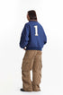 Back view of blue work jacket showing large number one patch