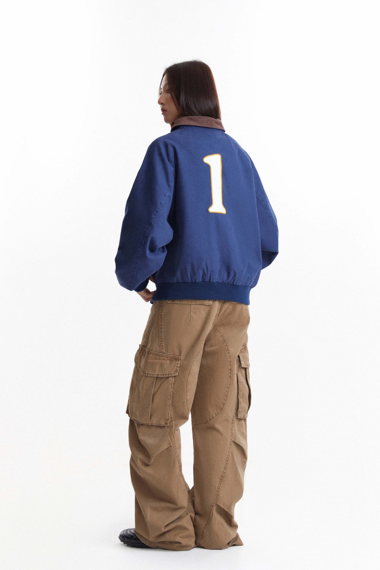 Back view of blue work jacket showing large number one patch