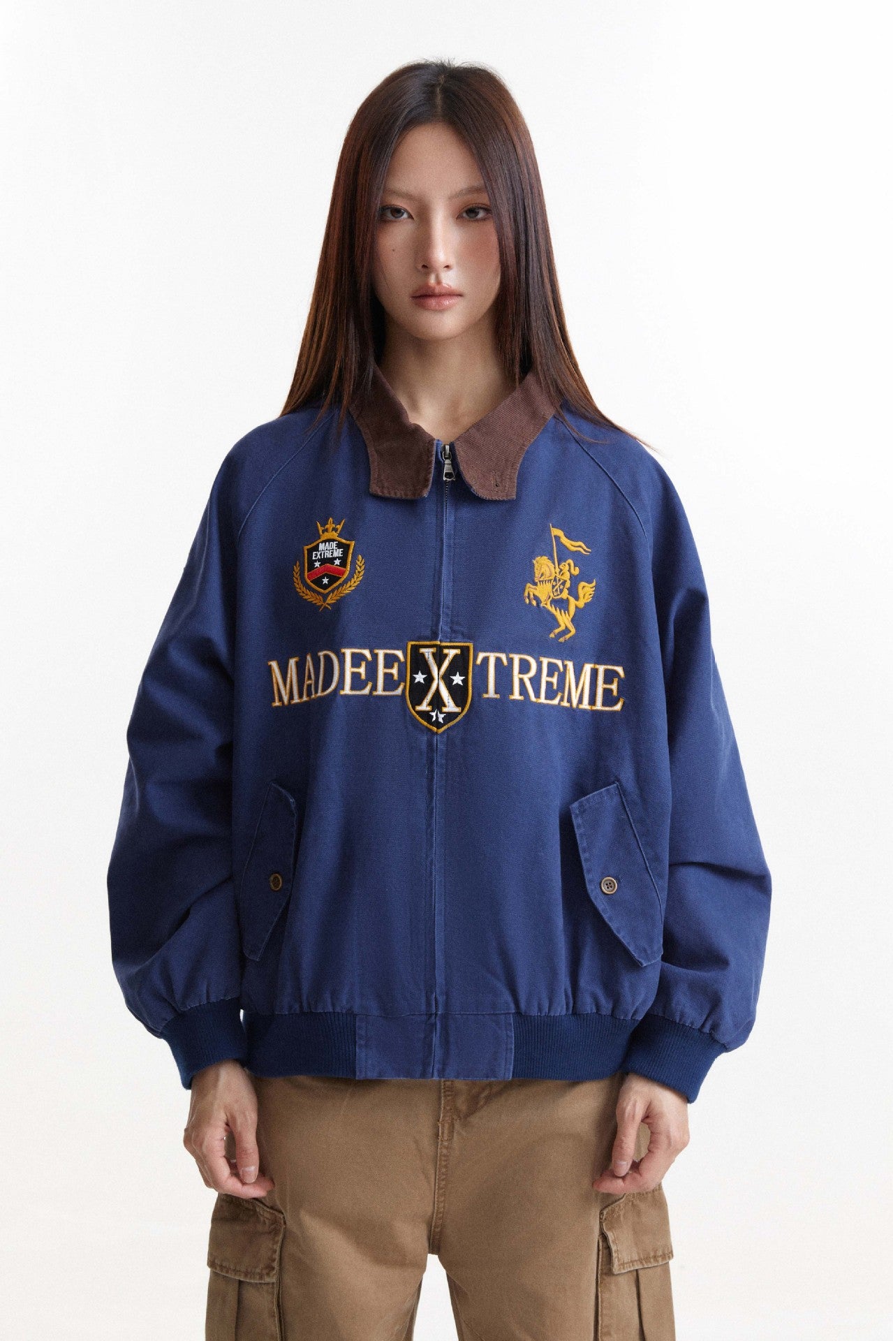 Close front view of blue embroidered jacket with brown contrast collar