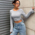 crop tops for women, gray ribbed knit, crew neck, bell sleeves, three-quarter view by wall