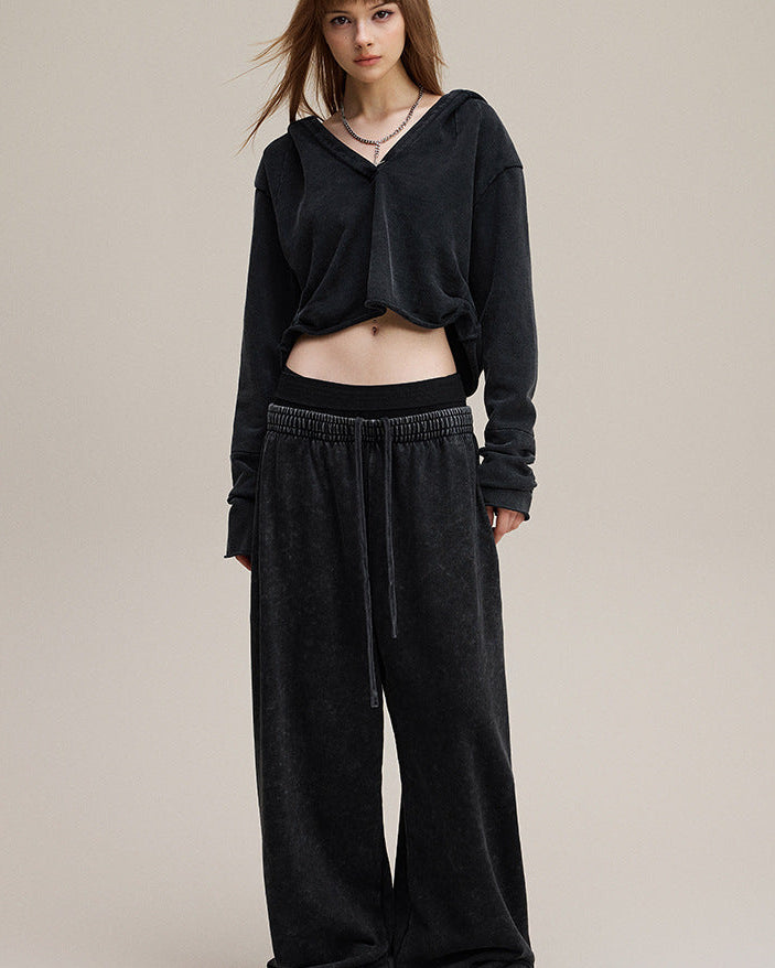 Model front view in black cropped hoodie—boxy crop with raw hem.