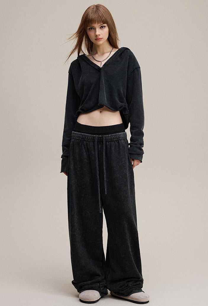 Model front view in black cropped hoodie—boxy crop with raw hem.